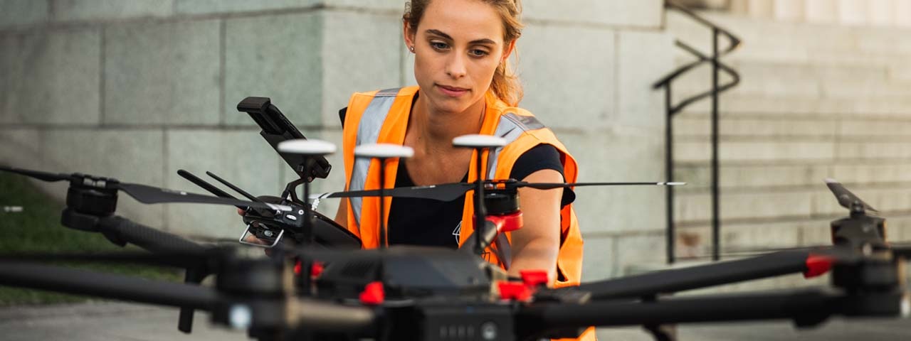 Woman setting up drone in high vis vest