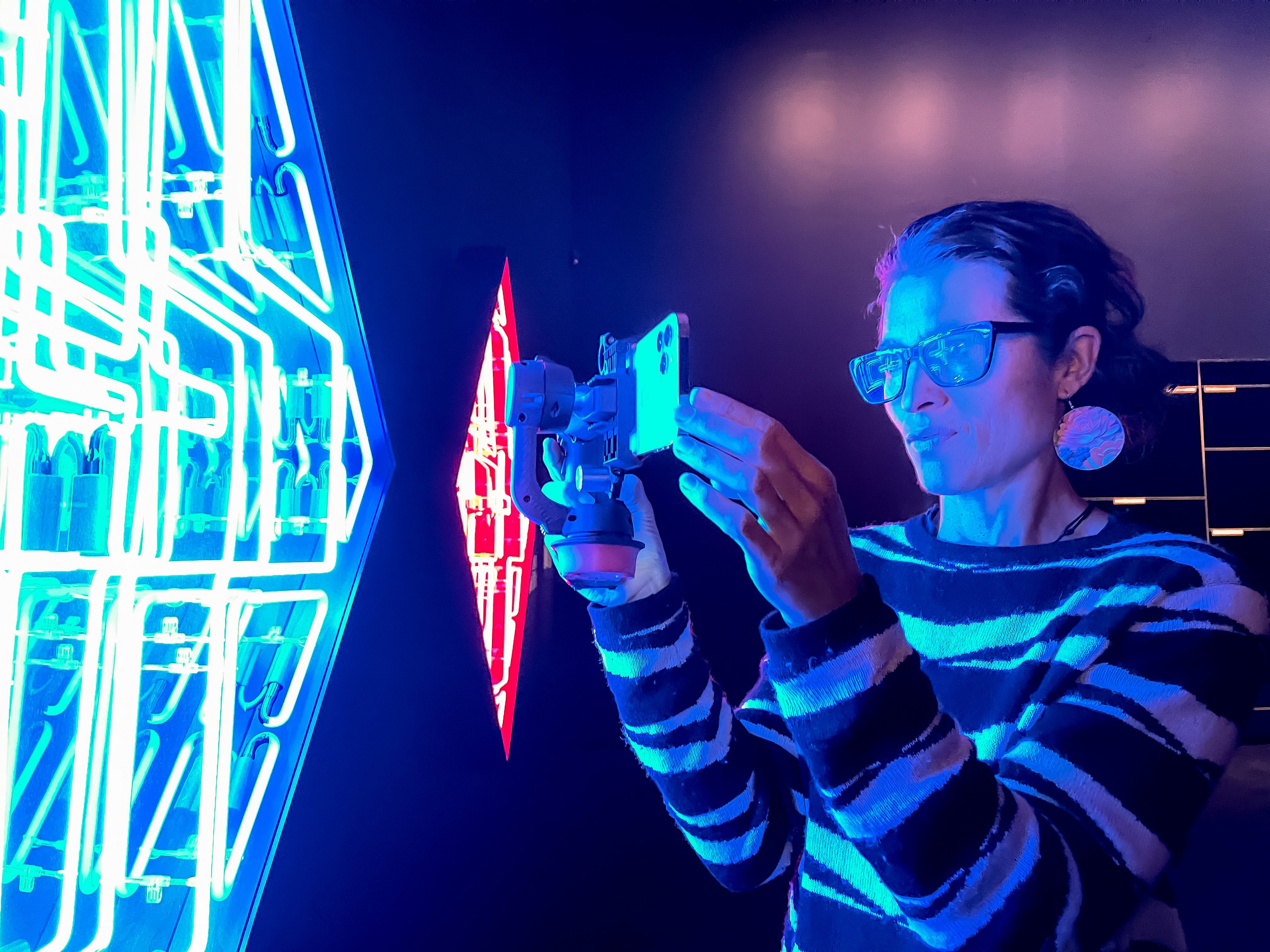 Chelsea Winstanley filming blue neon lights on an iPhone