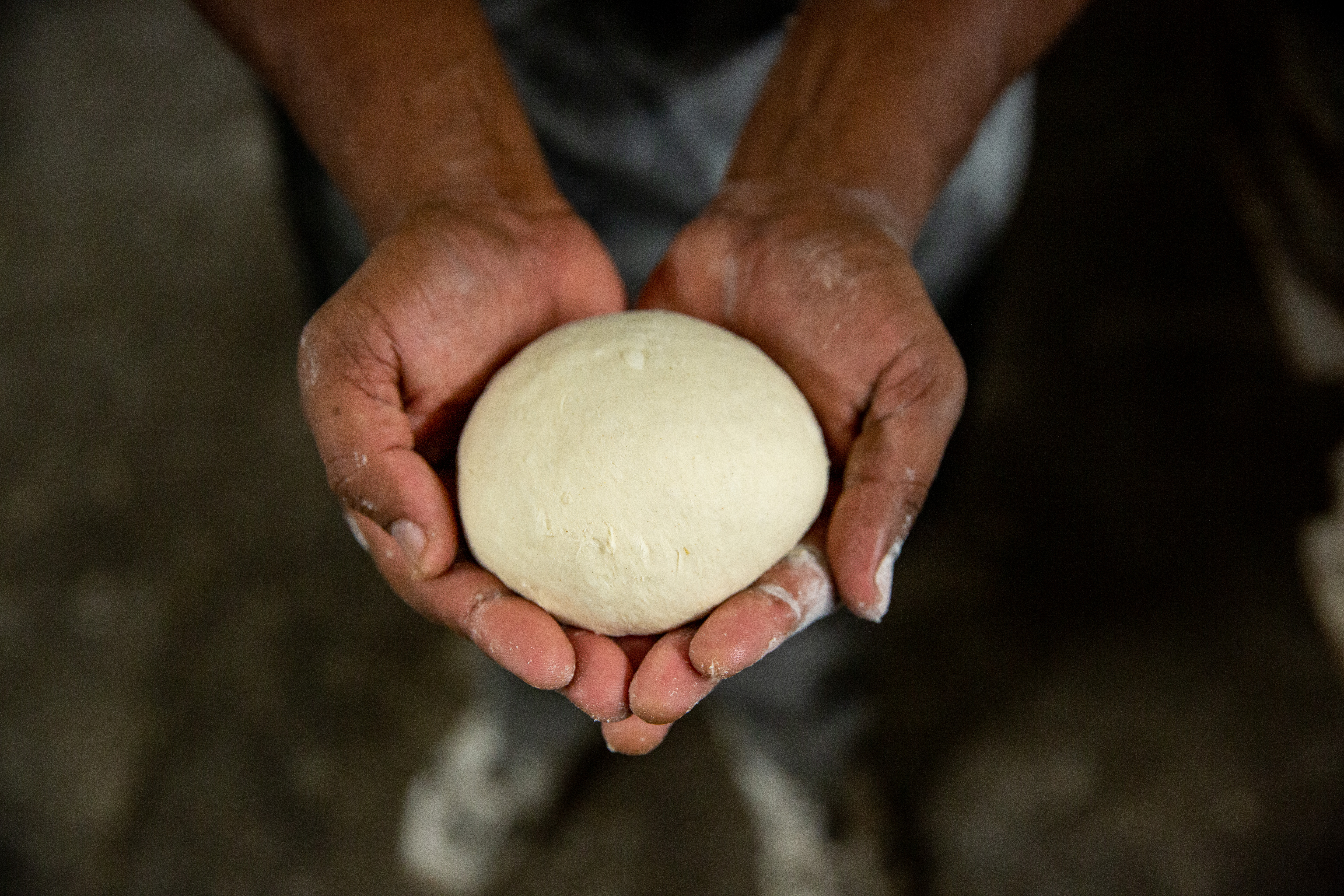 Bread dough cupped in palm of hands