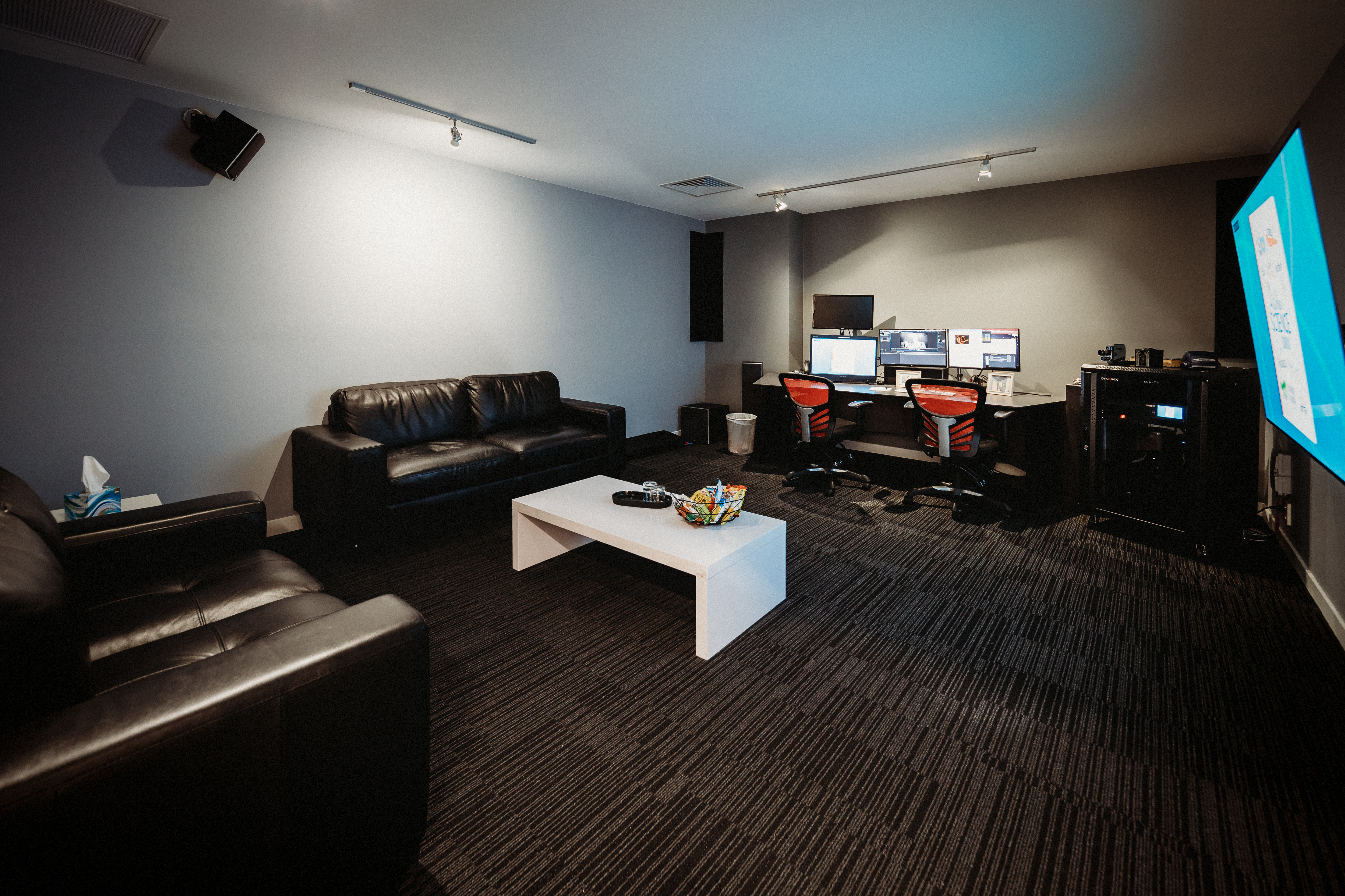 room with computers and couches showing editing suite