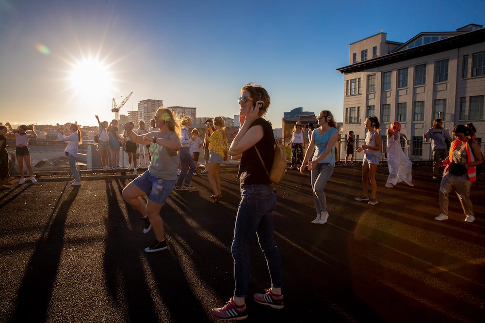 Group of people dancing at sunrise