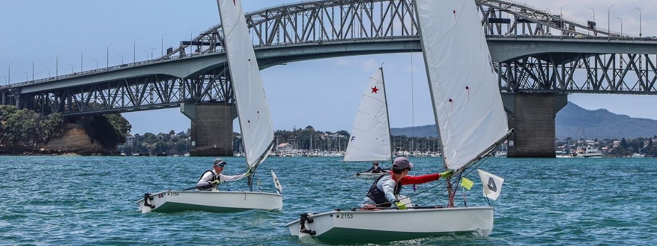 Two sailboats on the water under the Harbour Bridge