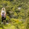 Two people ziplining through trees on Waiheke Island