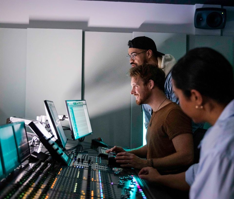 Tech Auckland - People - Sound engineers working on mixing desk in studio