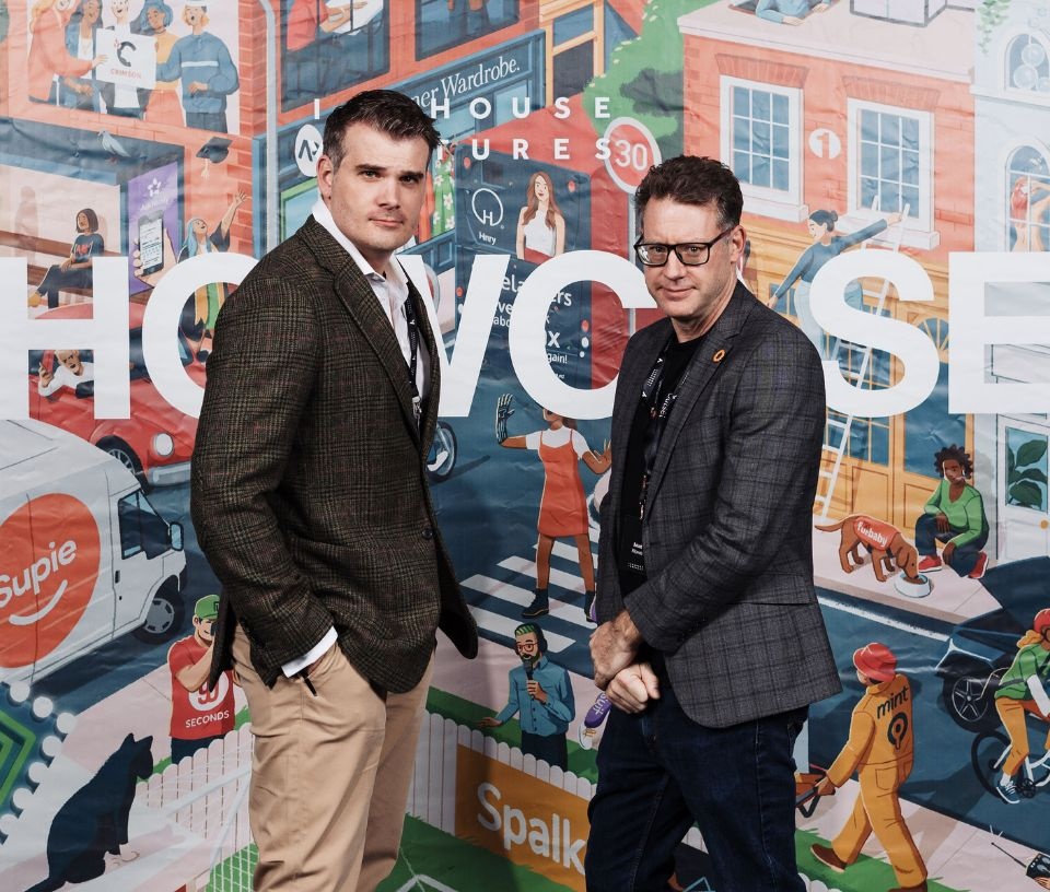 Tech Auckland - Community - Two men pose in front of mural at Icehouse Ventures