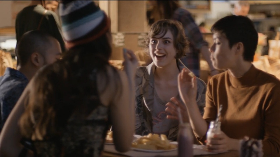 Group of Millennial's sitting around eating in cafe