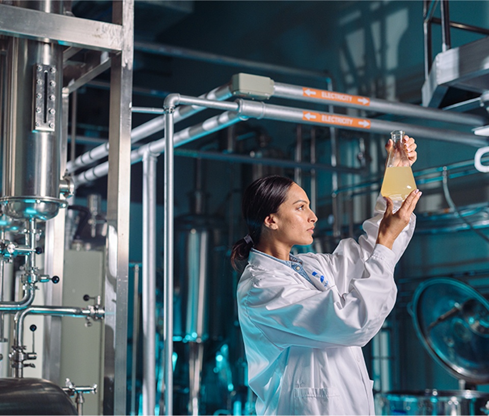 Female food and beverage food technologist looking at a sample of liquid