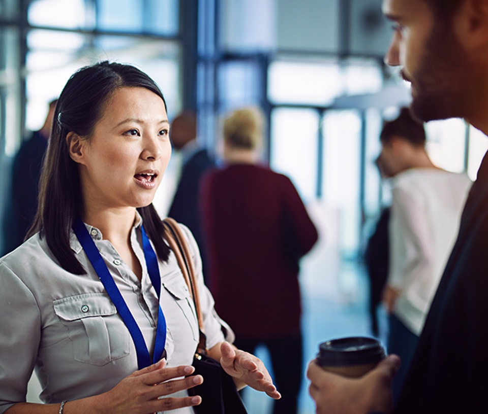 Woman in conversation with a man at networking event