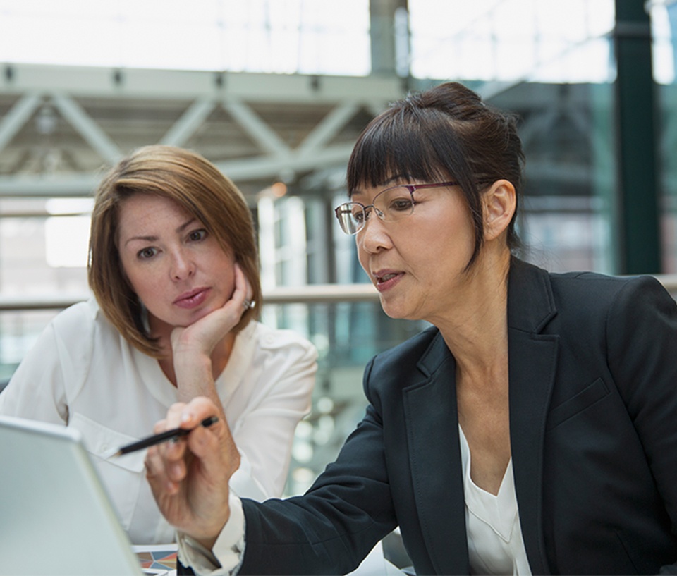 Two females discussing work while looking at a laptop