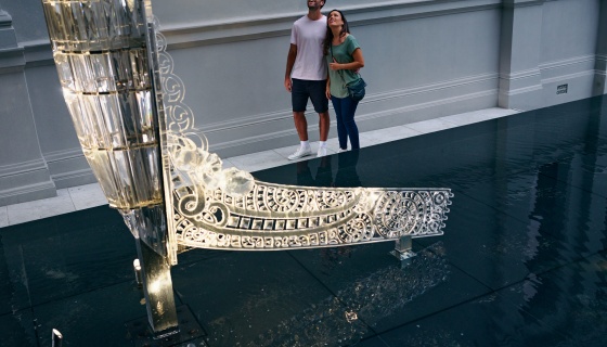 A couple observe the Crystal Waka at Auckland Art Gallery