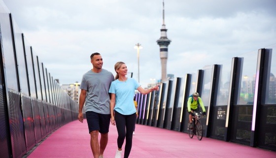 Couple walking along the Lightpath with the Sky Tower behind them