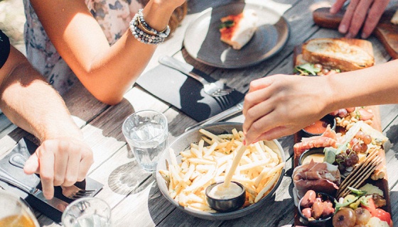 Birds eye view of friends eating platters al fresco at a casual eatery on Waiheke Island