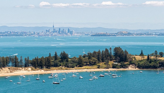 Motuihe Island with boats in the harbour and Auckland city in the background