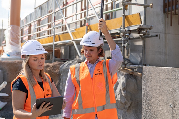 Female and male construction workers studying plans
